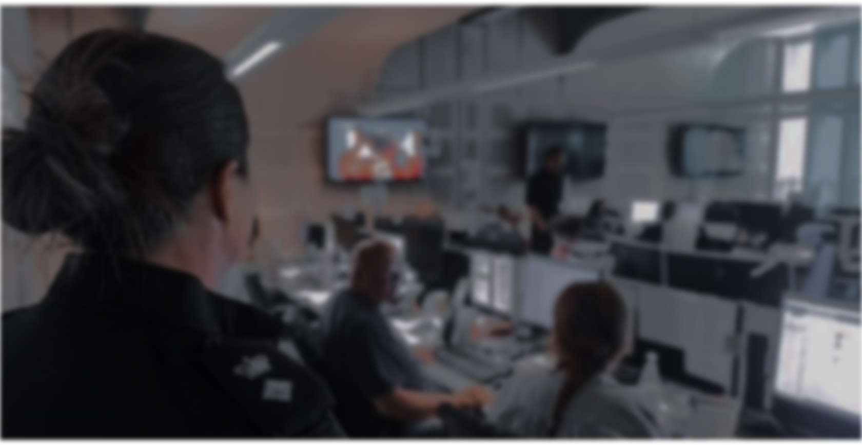 Looking over an officers shoulder into a busy control room